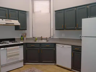 a kitchen with black cabinets and a white refrigerator at 2 Blocks from TQL Stadium 2BR 1.5BA in Cincinnati