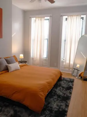 a bedroom with a large bed and two windows at 2 Blocks from TQL Stadium 2BR 1.5BA in Cincinnati