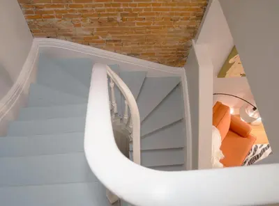 a spiral staircase in a room with a brick wall at 2 Blocks from TQL Stadium 2BR 1.5BA in Cincinnati