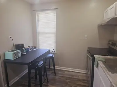a kitchen with a table with chairs and a microwave at Comfy 1BR Apt. in Pleasant Ridge in Cincinnati