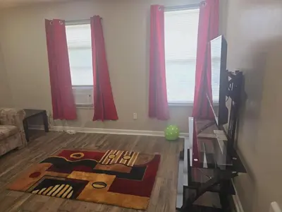 a living room with red curtains and a rug on the floor at Comfy 1BR Apt. in Pleasant Ridge in Cincinnati