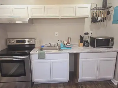 a kitchen with white cabinets and a sink and a microwave at Comfy 1BR Apt. in Pleasant Ridge in Cincinnati