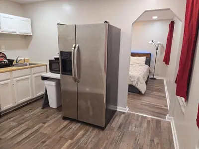 a kitchen with a stainless steel refrigerator and a bed at Cozy 1BR in Pleasant Ridge in Cincinnati
