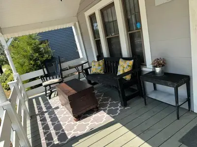 a porch with two benches and a table on a house at Spacious Relaxing Baltimore Home with Hot Tub in Baltimore