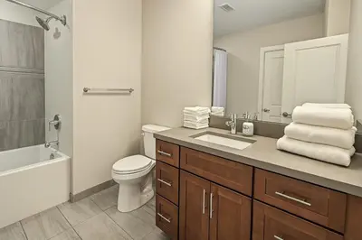 a bathroom with a sink and a toilet and a tub at Spacious Downtown Sq Stadium, Casino, R&R HoF in Cleveland