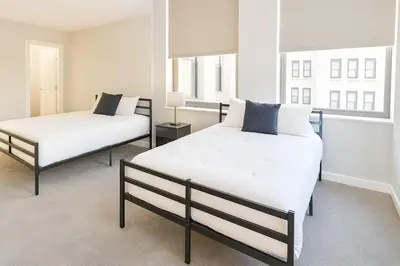 two beds in a room with two windows at Spacious Downtown Sq Stadium, Casino, R&R HoF in Cleveland