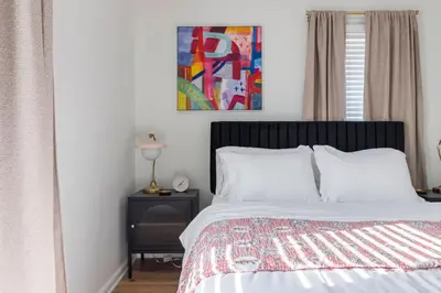 a bedroom with a bed and a painting on the wall at Family Friendly 3BR with Sunroom and Outdoor Area in Maple Heights
