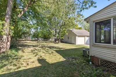 a yard of a house with trees and a house at Family Friendly 3BR with Sunroom and Outdoor Area in Maple Heights
