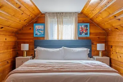 a bed in a room with wooden walls and ceilings at Family Friendly 3BR with Sunroom and Outdoor Area in Maple Heights