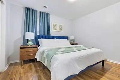 a bedroom with a large bed with blue curtains at Heights Dream Libby Unit 6 in Maple Heights