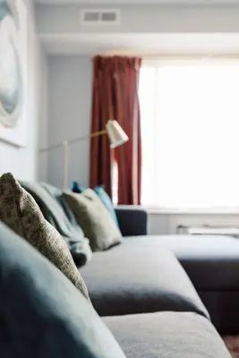a living room with a blue couch and a window at Heights Dream Libby Unit 6 in Maple Heights