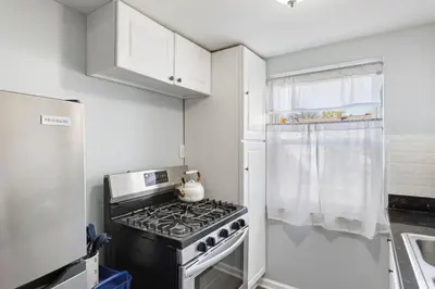 a small kitchen with a stove and a refrigerator at Heights Dream Libby Unit 6 in Maple Heights