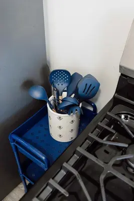 a cup filled with utensils sitting on a stove at Heights Dream Libby Unit 6 in Maple Heights