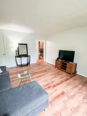 a living room with a couch and a flat screen tv at Akron Abode - 2pm Check In & Out in Akron