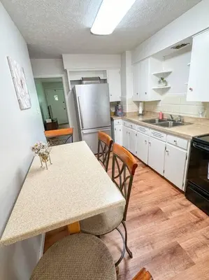 a kitchen with a table and chairs and a refrigerator at Akron Abode - 2pm Check In & Out in Akron