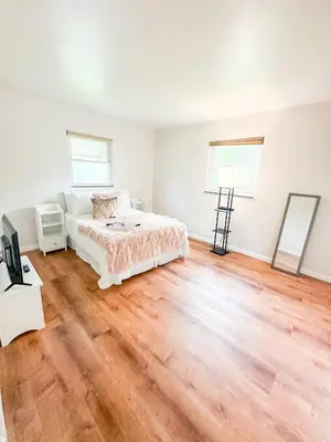 a bedroom with a bed and a wooden floor at Akron Abode - 2pm Check In & Out in Akron