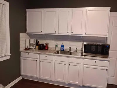 a kitchen with white cabinets and a sink and a microwave at Experience a home near Cleveland Clinic & parks in Cleveland