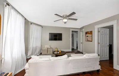 a living room with a white couch and a ceiling fan at Spacious 3-Bed In Vibrant Tremont in Cleveland