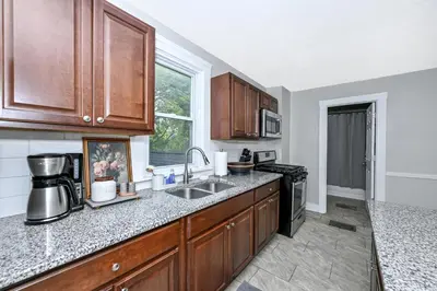 a kitchen with wooden cabinets and a sink at Spacious 3-Bed In Vibrant Tremont in Cleveland