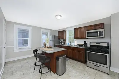 a kitchen with wooden cabinets and a stove top oven at Spacious 3-Bed In Vibrant Tremont in Cleveland