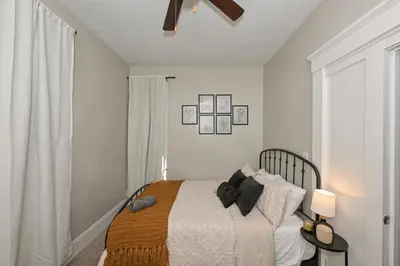 a white bedroom with a bed and a window at 3 Bed Spacious 1st Floor Apt at Tremont in Cleveland