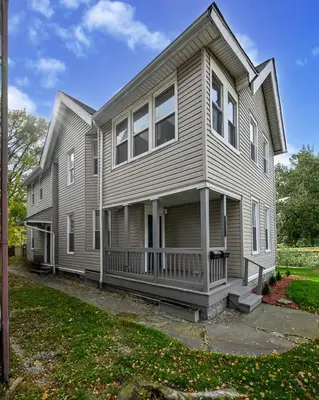 a gray house with a porch and a yard at 3 Bed Spacious 1st Floor Apt at Tremont in Cleveland