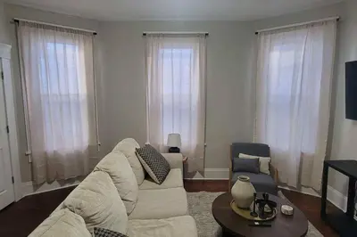 a living room with a white couch and a table at 3 Bed Spacious 1st Floor Apt at Tremont in Cleveland