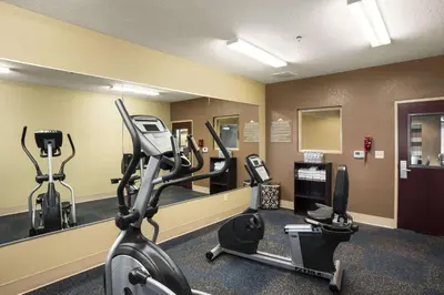 a gym with a treadmill and elliptical machines at Microtel Inn and Suites Carrollton in Carrollton