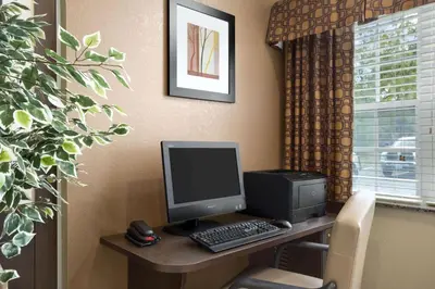 a desk with a computer and a monitor and keyboard at Microtel Inn and Suites Carrollton in Carrollton