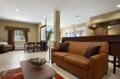 a living room with a couch and a table at Microtel Inn and Suites Carrollton in Carrollton