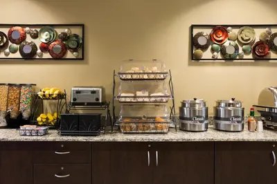 a kitchen counter with some food and plates on the wall at Microtel Inn and Suites Carrollton in Carrollton