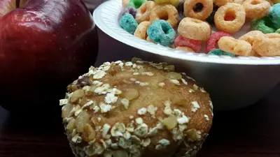a table with a bowl of cereal and an apple at Microtel Inn and Suites Carrollton in Carrollton