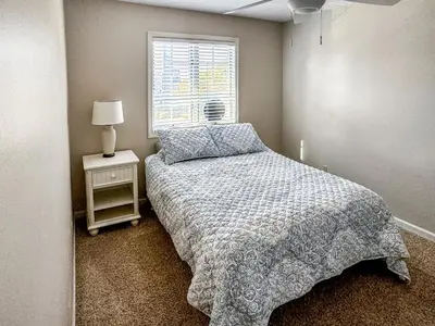 a small bedroom with a bed and a window at New! Kelleys Island Condo in Kelleys Island