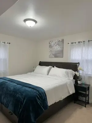 a bedroom with a large bed with white sheets at Beautiful 2 BDRM Ocean Inspired Oasis in Youngstown