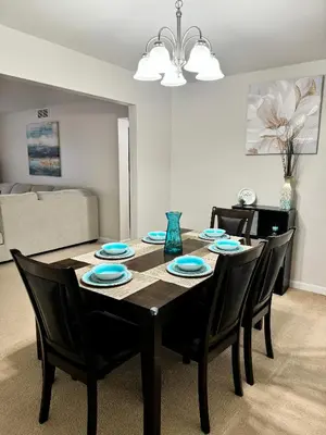 a dining room table with black chairs and blue plates at Beautiful 2 BDRM Ocean Inspired Oasis in Youngstown