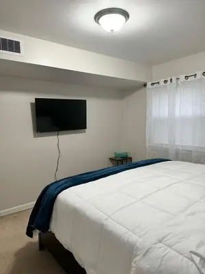 a bedroom with a bed and a flat screen tv at Beautiful 2 BDRM Ocean Inspired Oasis in Youngstown