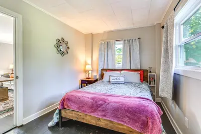 a bedroom with a bed with a purple blanket at Large Yard and Fire Pit Pet-Friendly Ravenna Home! in Streetsboro