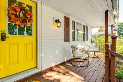 a yellow door on a porch with a table and chairs at Large Yard and Fire Pit Pet-Friendly Ravenna Home! in Streetsboro
