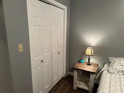 a bedroom with a white door and a table with a lamp at Cozy apartment embedded in Kentucky mountains in Hagerhill