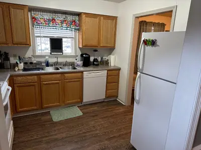 a kitchen with a white refrigerator and wooden cabinets at Cozy apartment embedded in Kentucky mountains in Hagerhill