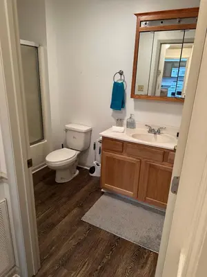 a bathroom with a toilet and a sink and a mirror at Cozy apartment embedded in Kentucky mountains in Hagerhill