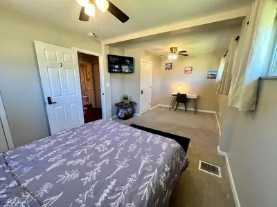 a bedroom with a bed and a table with a candle at Sunny Stay Bright and Cozy Suite 2 in Cincinnati