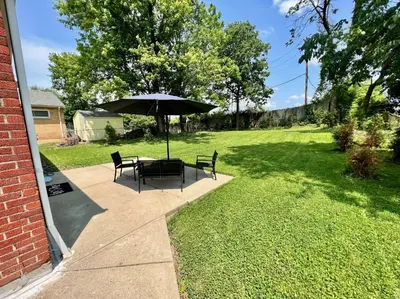 a table and chairs with an umbrella in a yard at Sunny Stay Bright and Cozy Suite 2 in Cincinnati