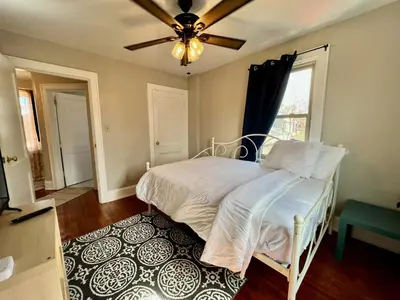 a bedroom with a white bed and a ceiling fan at Cozy Bungalow Quiet Neighborhood Queen Bed Suite 3 10 Min to Downtown in Cincinnati