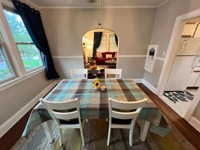 a dining room with a glass table and chairs at Cozy Bungalow Quiet Neighborhood Queen Bed Suite 3 10 Min to Downtown in Cincinnati
