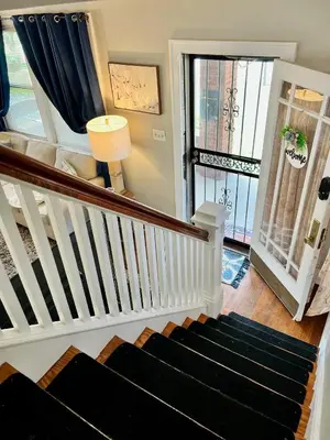 a staircase with a black rug in a living room at Cozy Bungalow Quiet Neighborhood Queen Bed Suite 3 10 Min to Downtown in Cincinnati