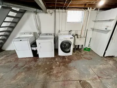a laundry room with two washing machines and a sink at Comfy Cozy Bungalow Suite 2 10 min from Downtown in Cincinnati