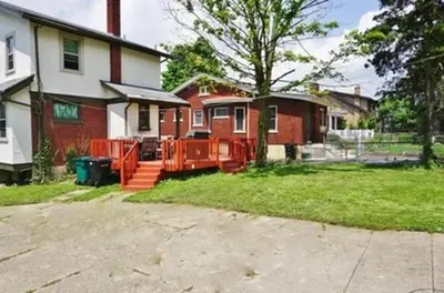 a house with an orange fence in the yard at Comfy Cozy Bungalow Suite 2 10 min from Downtown in Cincinnati