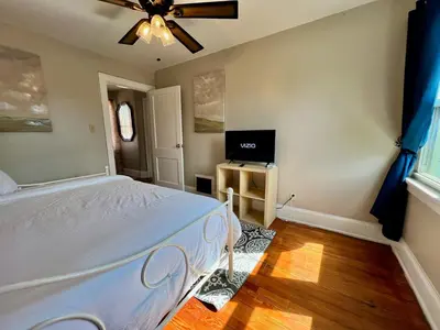 a bedroom with a bed and a flat screen tv at Comfy Cozy Bungalow Suite 2 10 min from Downtown in Cincinnati