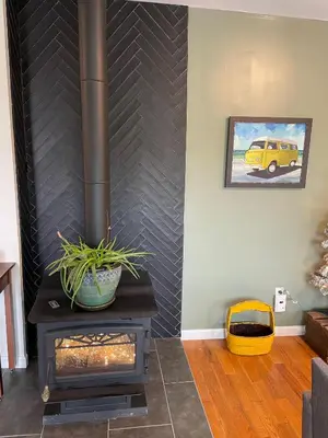 a wood stove in a living room with a wall at River House on the Little Miami in Milford